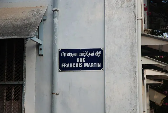 本地治里淺色牆面上的深藍雙語街牌，上為泰米爾文，下為RUE FRANCOIS MARTIN。