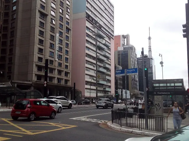 聖保羅Paulista與Augusta藍色街牌，周圍可見高樓、車流及Consolação地鐵入口。