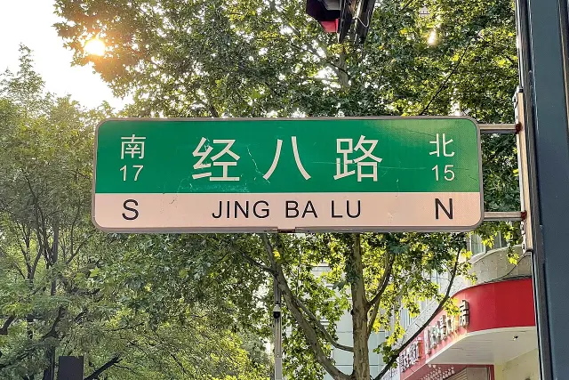 鄭州經八路綠色街牌，下方有拼音，左右分別標示南十七與北十五。