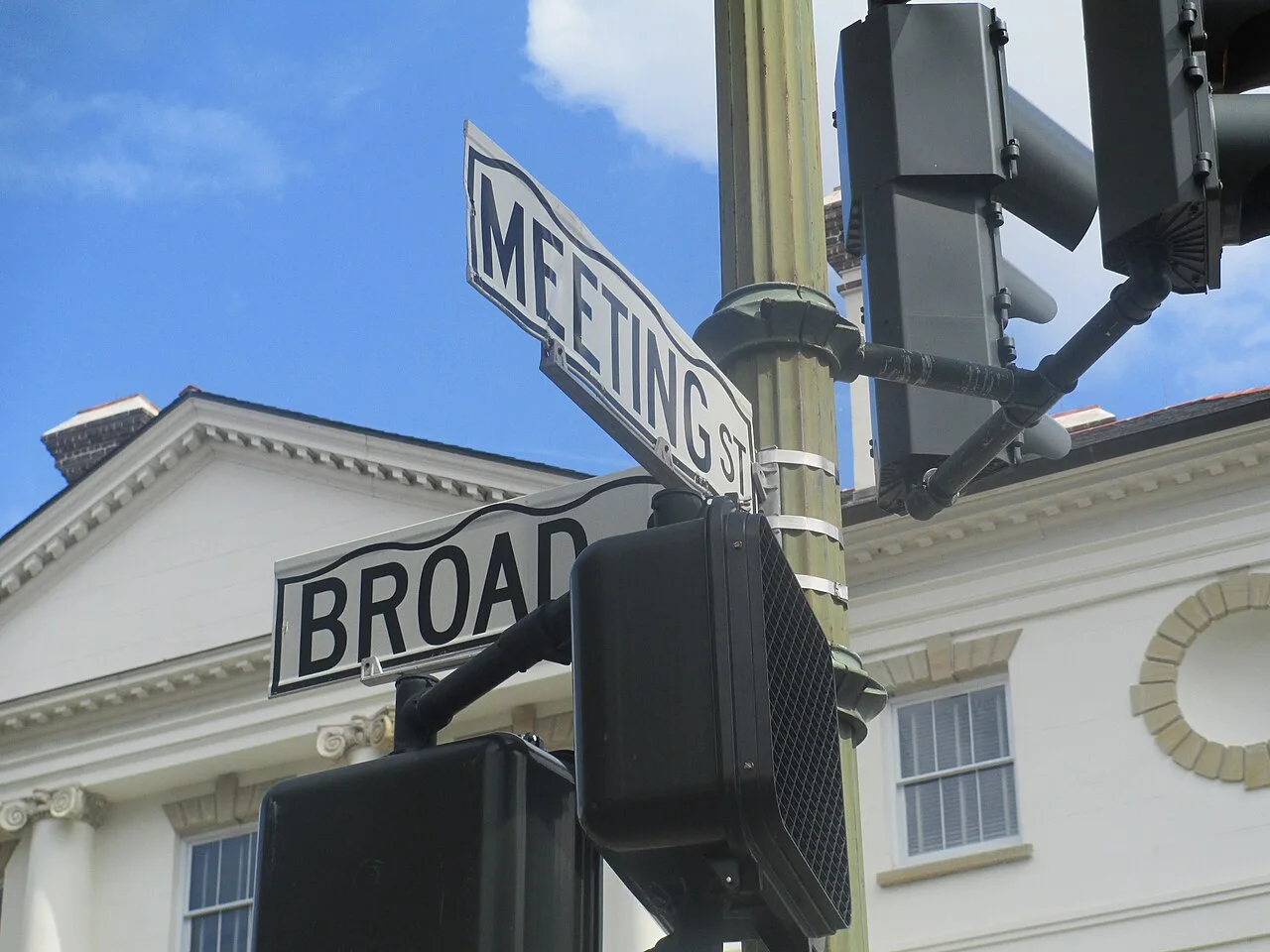 查爾斯頓Broad與Meeting Street的白底黑字造型街牌，Broad牌右端有遮擋。