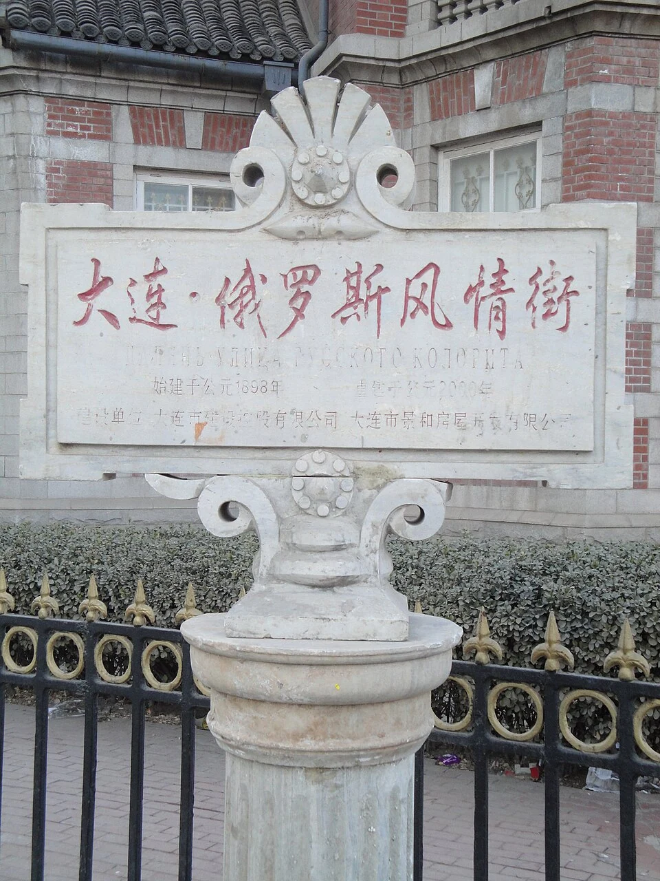 大連俄羅斯風情街的石質入口標誌，紅色中文字下方可見褪色的俄文。