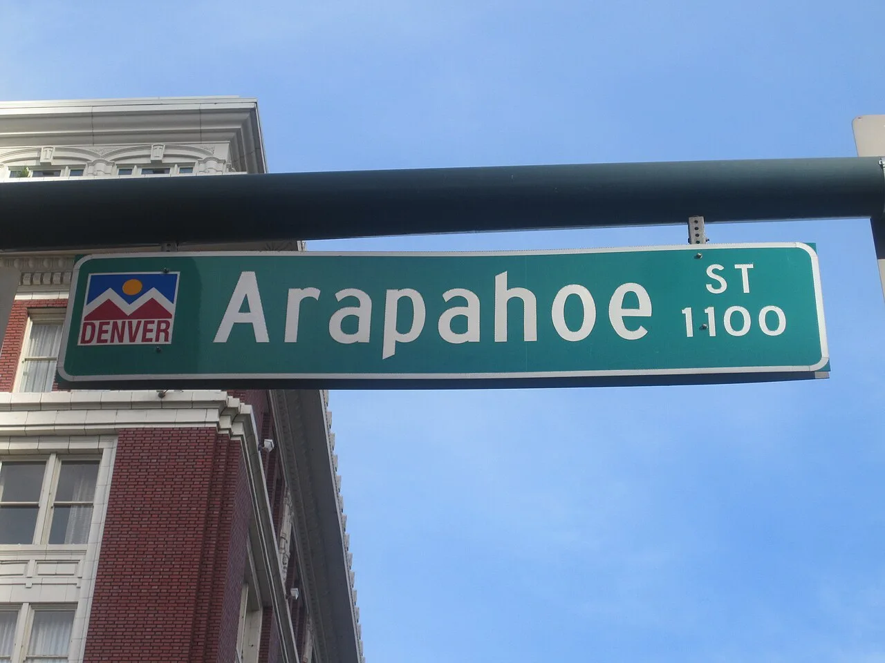 丹佛綠底白字Arapahoe St街牌與1100街區數字,左側可見城市圖案。