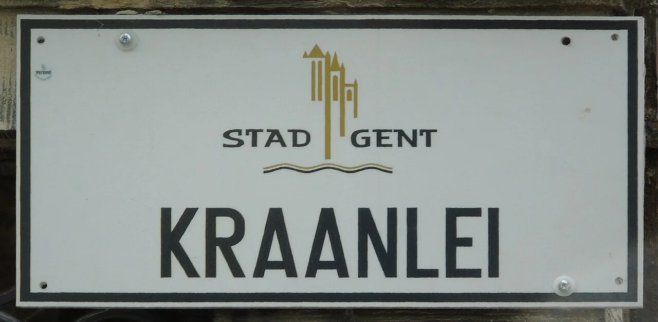 根特的實拍街牌。「KRAANLEI」是河岸街名;上方「STAD GENT」意為根特市,金色圖形是城市識別。