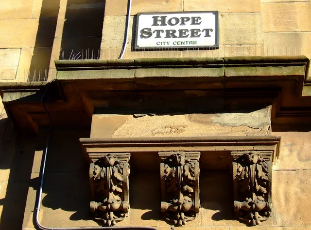格拉斯哥建築上方的HOPE STREET黑底白字街牌，下方小字CITY CENTRE。