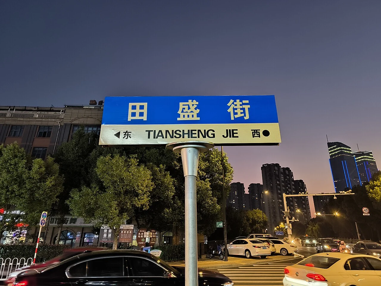 湖州田盛街的中英文街牌立於黃昏路口,下方可見東西方位與往來車輛。