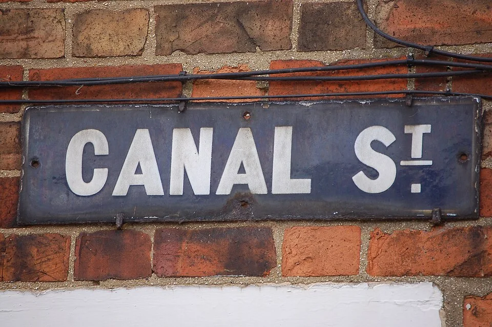 牛津傑里科紅磚牆上的CANAL St街牌，白字深藍灰底並帶鏽斑。