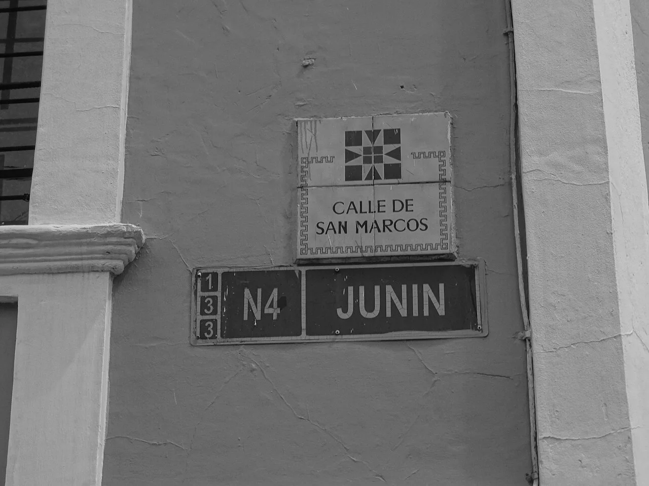 基多黑白照片中，CALLE DE SAN MARCOS方磚牌位於JUNÍN街牌上方。
