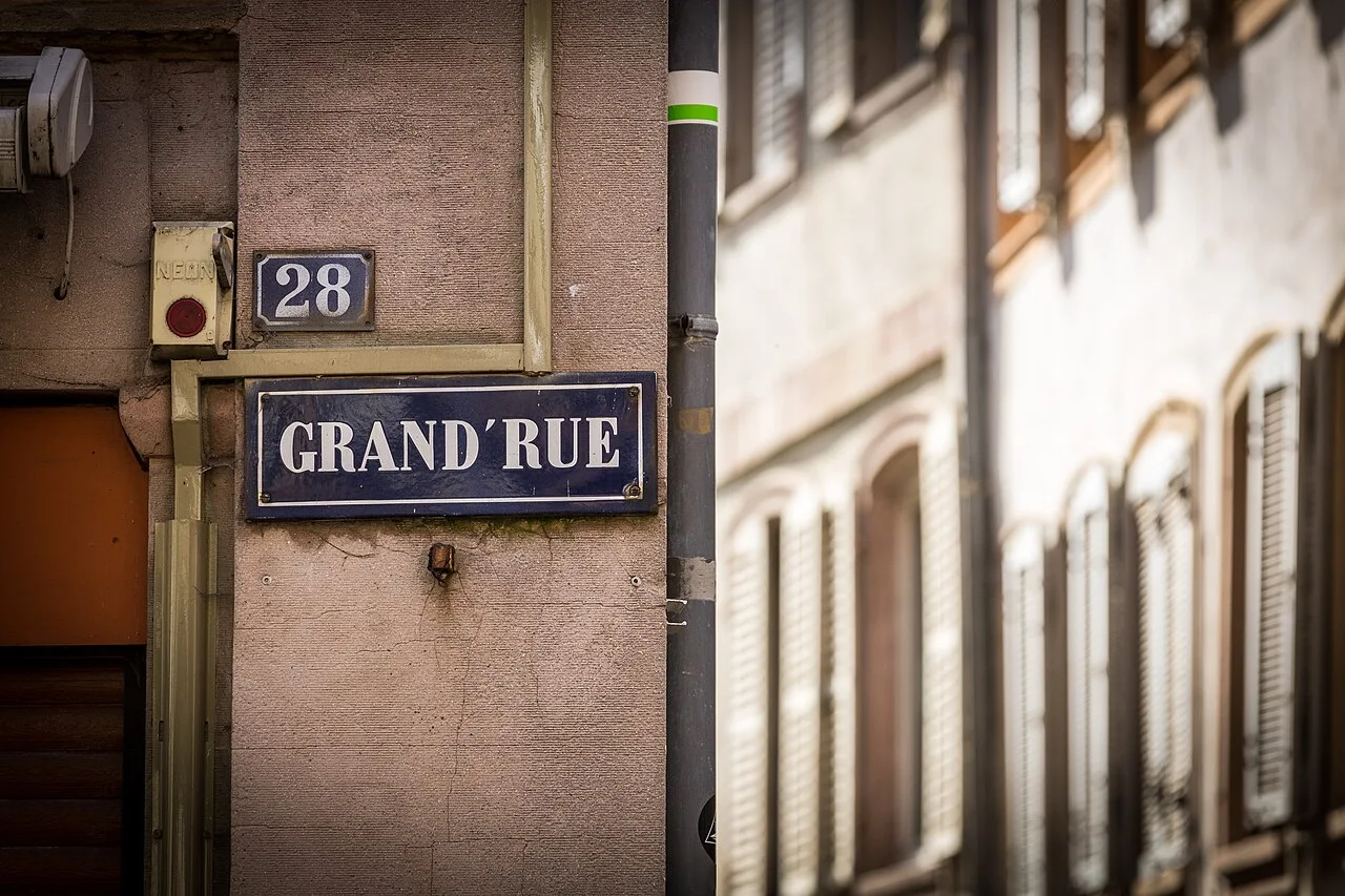 史特拉斯堡的實拍街牌。「GRAND’RUE」為大街名稱,上方獨立小牌「28」是門牌號碼;兩者合讀形成地址線索。