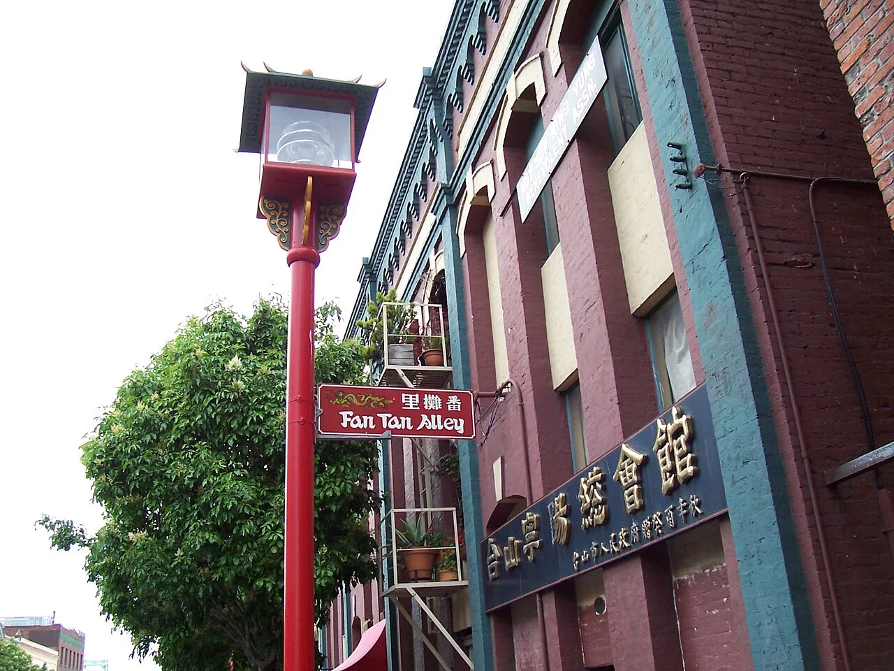 維多利亞番攤里入口紅色Fan Tan Alley牌,白色漢字右起為番攤里,旁有中式紅色路燈。